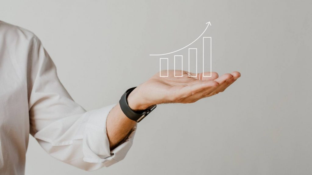 Pessoa com a mão estendida e um gráfico crescente sobre a palma da mão representando como fazer seu provedor de internet crescer.