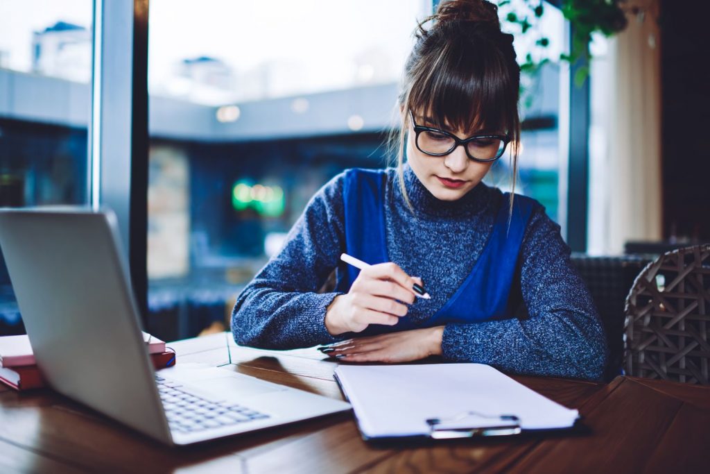 jovem estudando com papéis e computador como administrar um provedor de internet