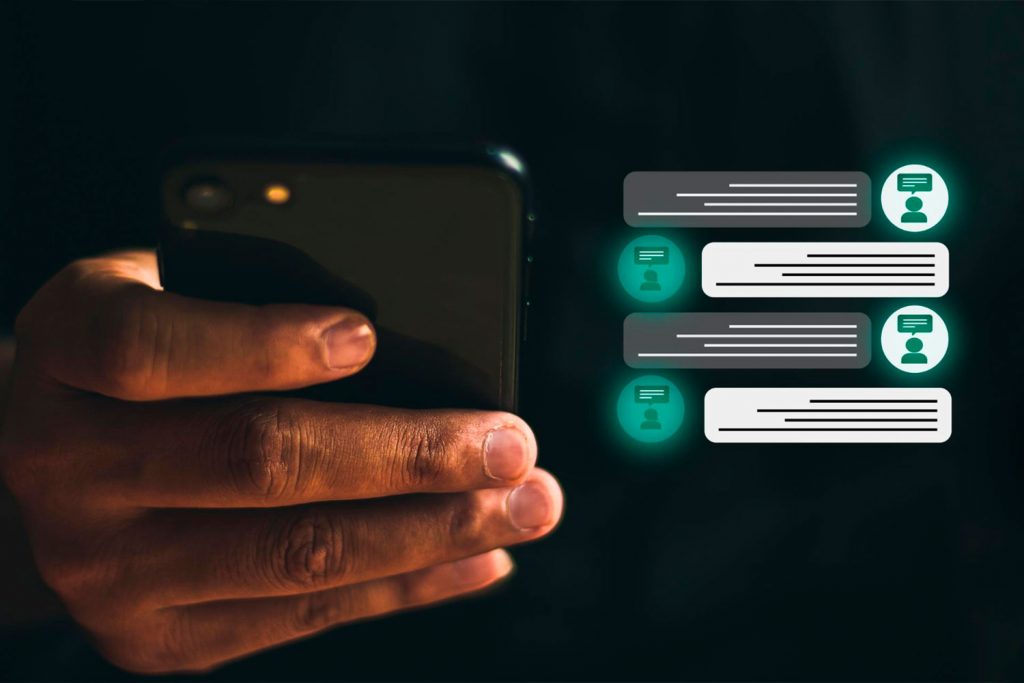 Pessoa segurando um smartphone e ícones de conversa de texto de um atendimento feito pelo chatbot para provedor de internet da mikweb