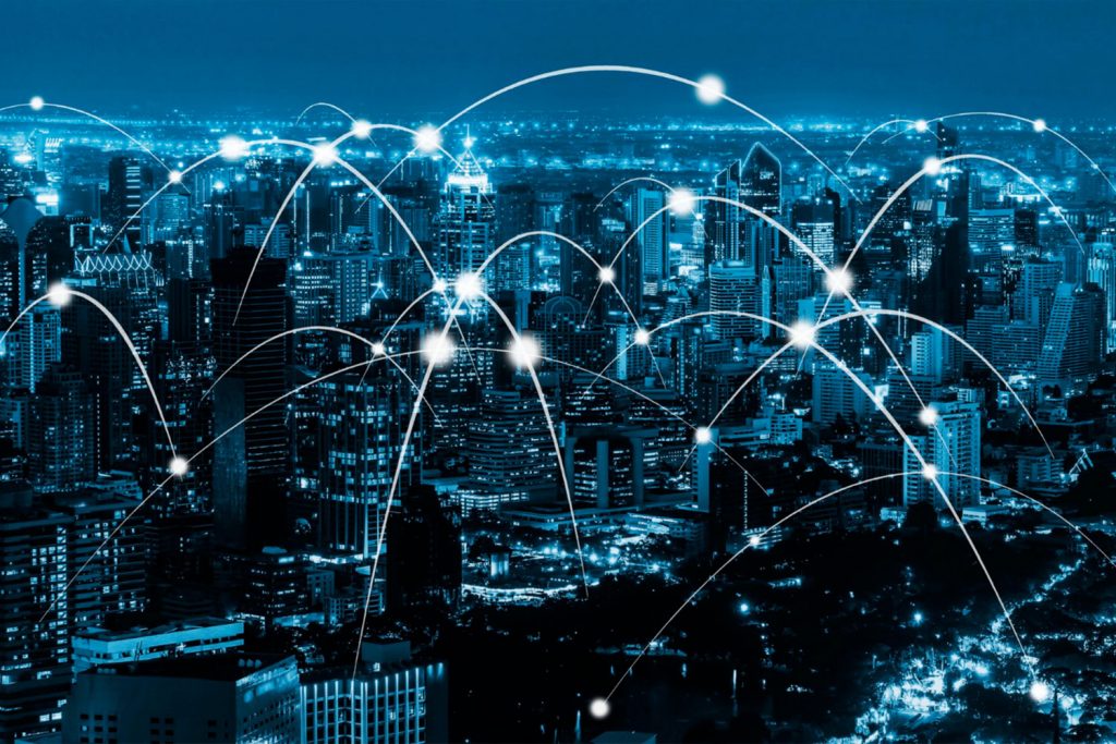 Cidade à noite com várias linhas interligando pontos de rede.