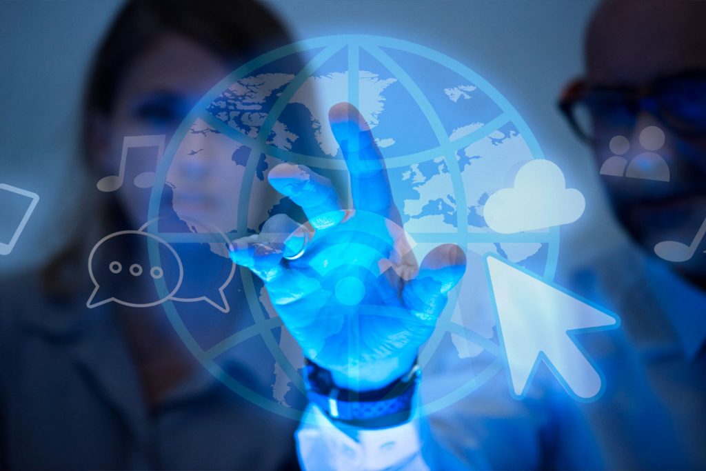 Duas pessoas ao fundo olhando para um globo terrestre digital e transparente com vários ícones de conectividade em volta.