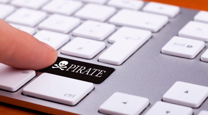 sistema-para-provedor-internet-crackeado Dedo selecionando uma tecla preta escrito “pirate” em um teclado de computador com teclas brancas.