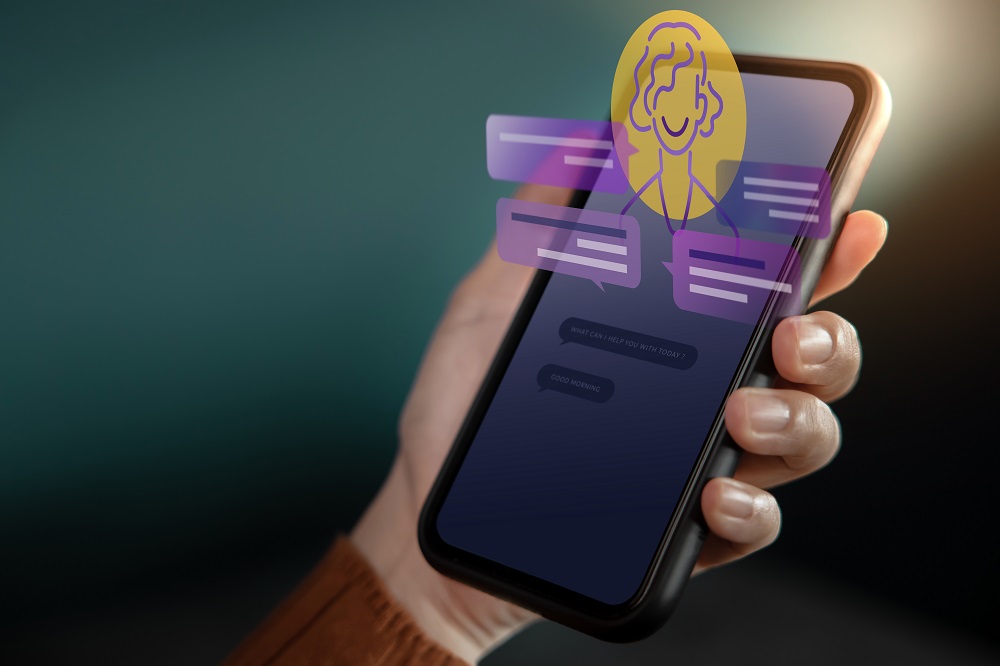 Pessoa segurando um smartphone, representando uma conversação com Inteligência Artificial de chatbots.
