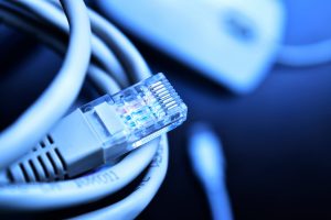 Cabo de internet enrolado com outros objetos desfocados ao fundo, representando splitter desbalanceado.