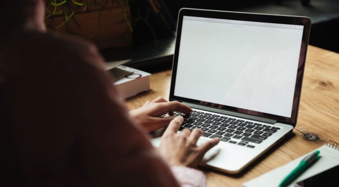 como-saber-meu-provedor-de-internet Pessoa no notebook buscando por informações de como saber qual o provedor de internet assina.