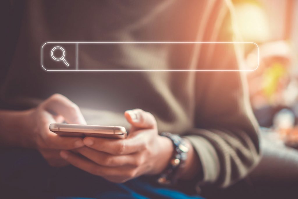 Pessoa com celular na mão verificando quem pode ver meu histórico do roteador