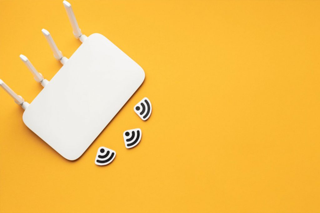 Roteador branco em fundo amarelo com símbolos de Wi-Fi, representando o resultado do provisionamento do sistema MikWeb.