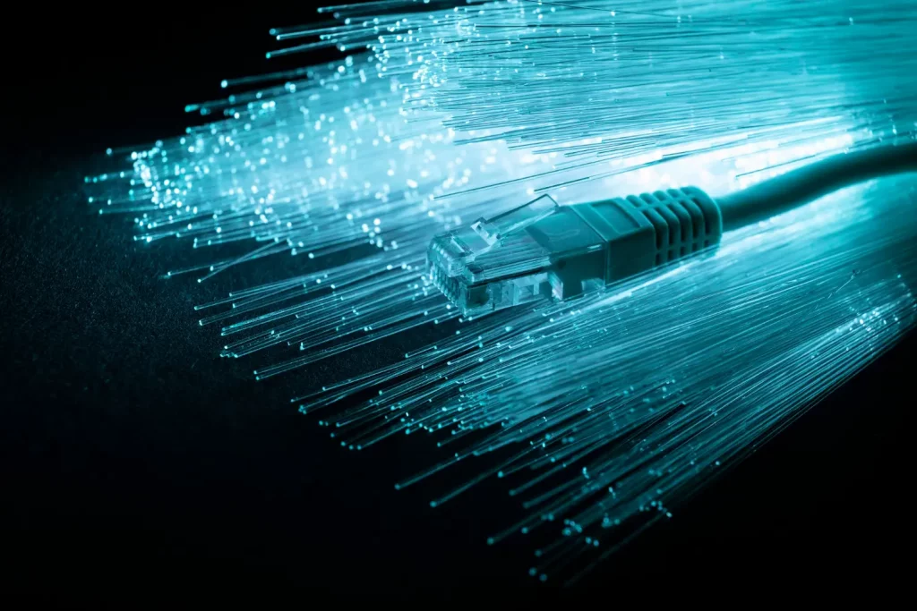Cabo de internet sobre vários filamentos iluminados, ilustrando a parte interna da fibra óptica.