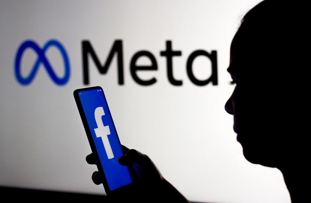 Pessoa segurando um celular com logo do Facebook e acessando as configurações de campanha do Facebook ads para provedores de internet.
