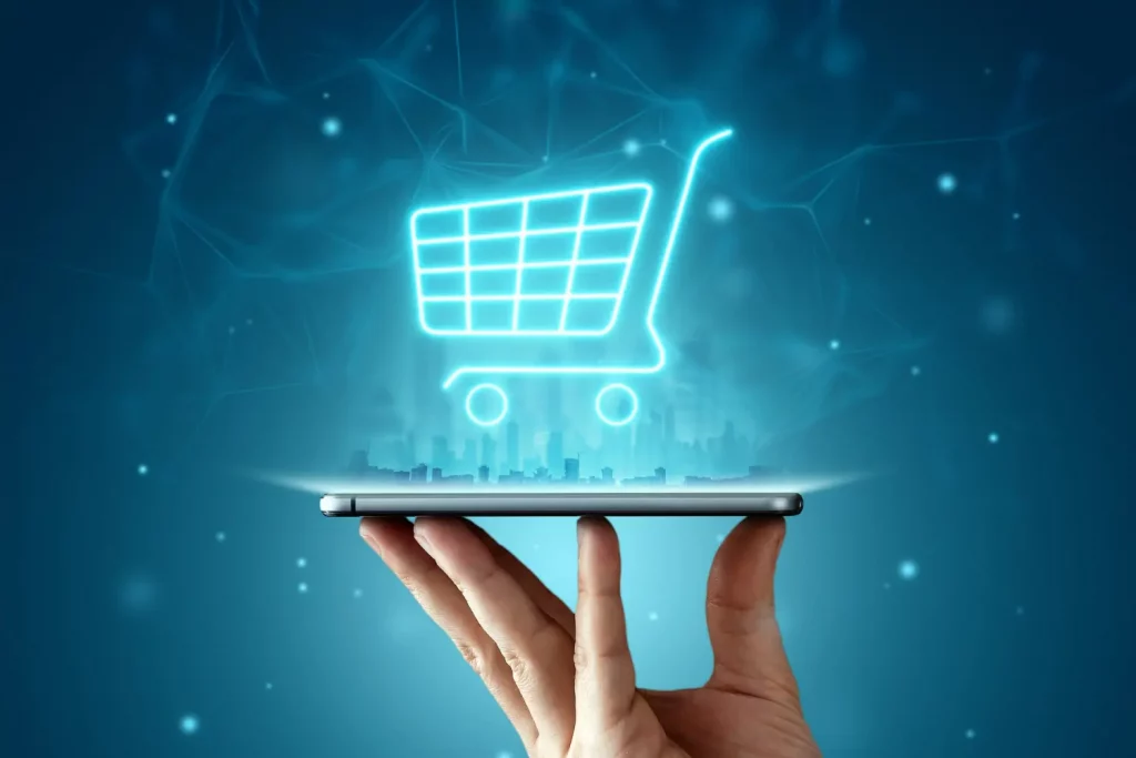 Holograma de carrinho de compras sobre um celular, representando como fazer seu site vender mais.