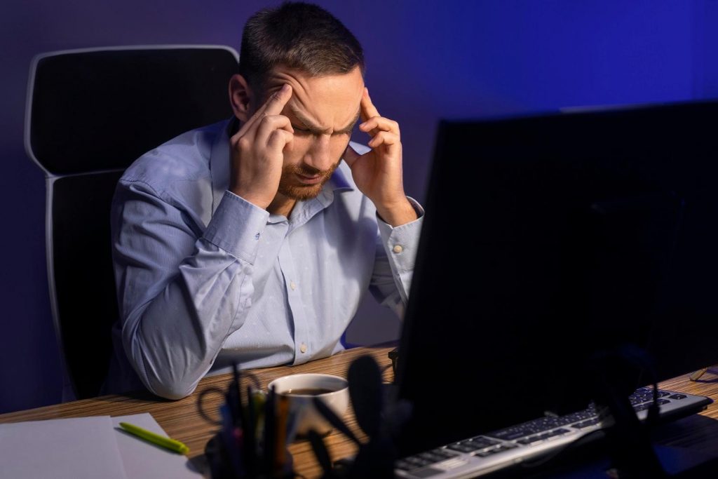 Dono de provedor de internet sentado em frente ao computador tentando resolver os problemas comuns de um provedor de internet.