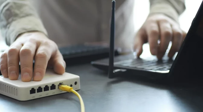 direitos-do-consumidor-para-provedor pessoa realizando e configurando um modem de internet após a contratação de serviço de um provedor de internet regional