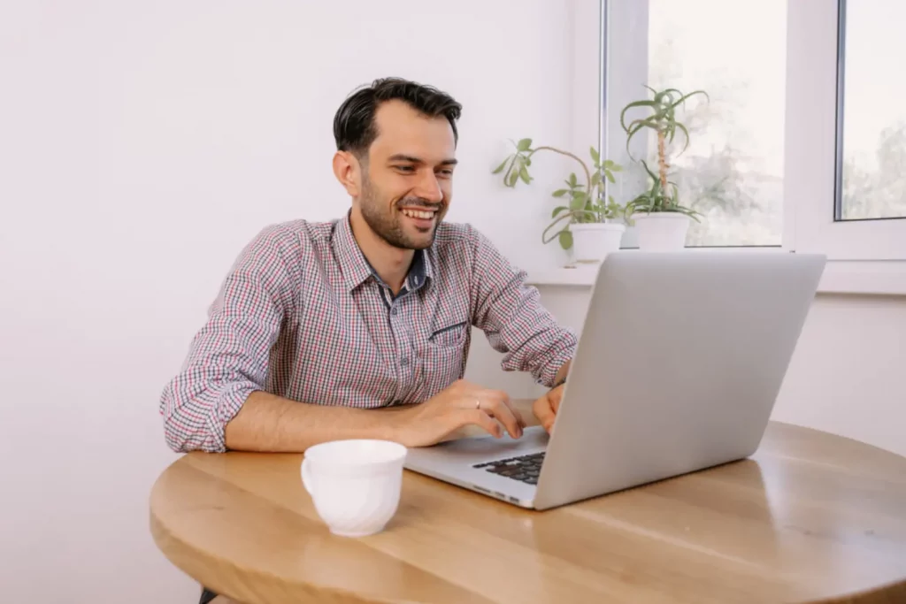 Homem trabalhando em seu notebook feliz com o provedor de internet local que contratou