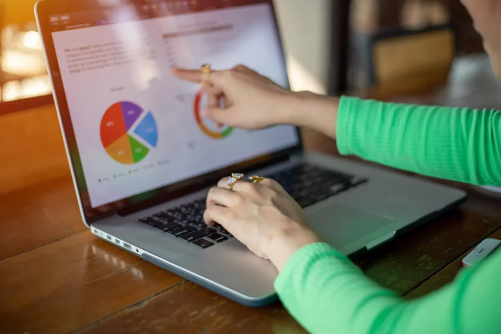 pessoa dona de um provedor de internet apontando para a tela do notebook e visualizando os seus principais indicadores de desempenho